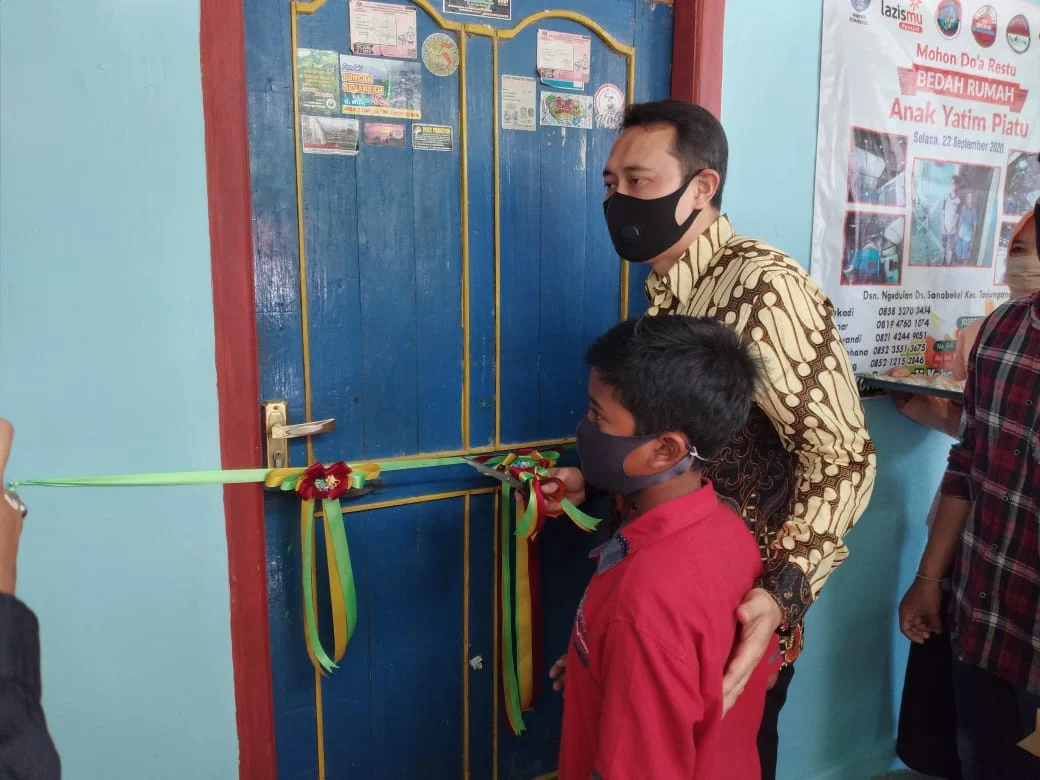 Pemotongan pita sebagai tanda selesainya proses renovasi rumah anak yatim piatu. Pemotongan pita oleh Bapak Novi Rahman Hidhayat selaku Bupati Nganjuk. (WebP)